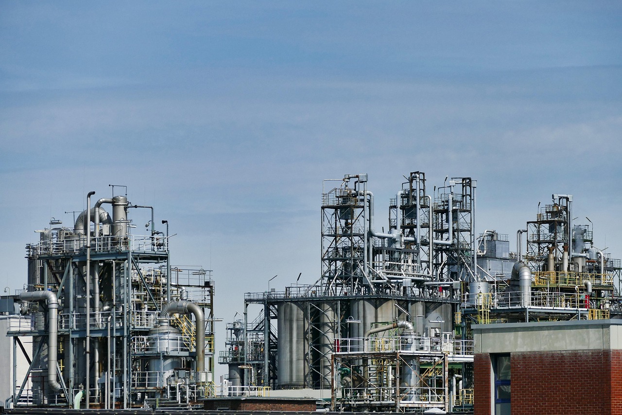 Industrial process plant with tanks and piping under a clear sky