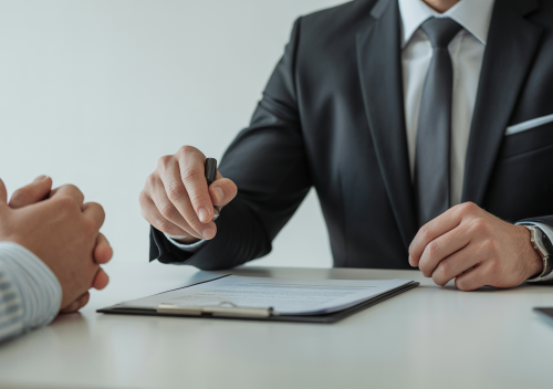 Abogado de accidentes interactuando empáticamente con un cliente en una oficina moderna, con documentos legales sobre el escritorio