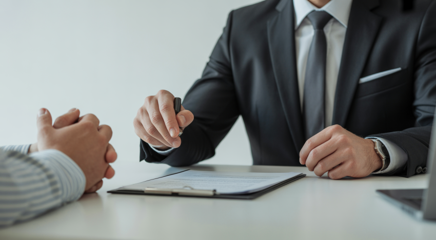 Abogado de accidentes interactuando empáticamente con un cliente en una oficina moderna, con documentos legales sobre el escritorio